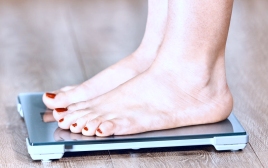 Close up of Caucasian female legs standing on the floor scales